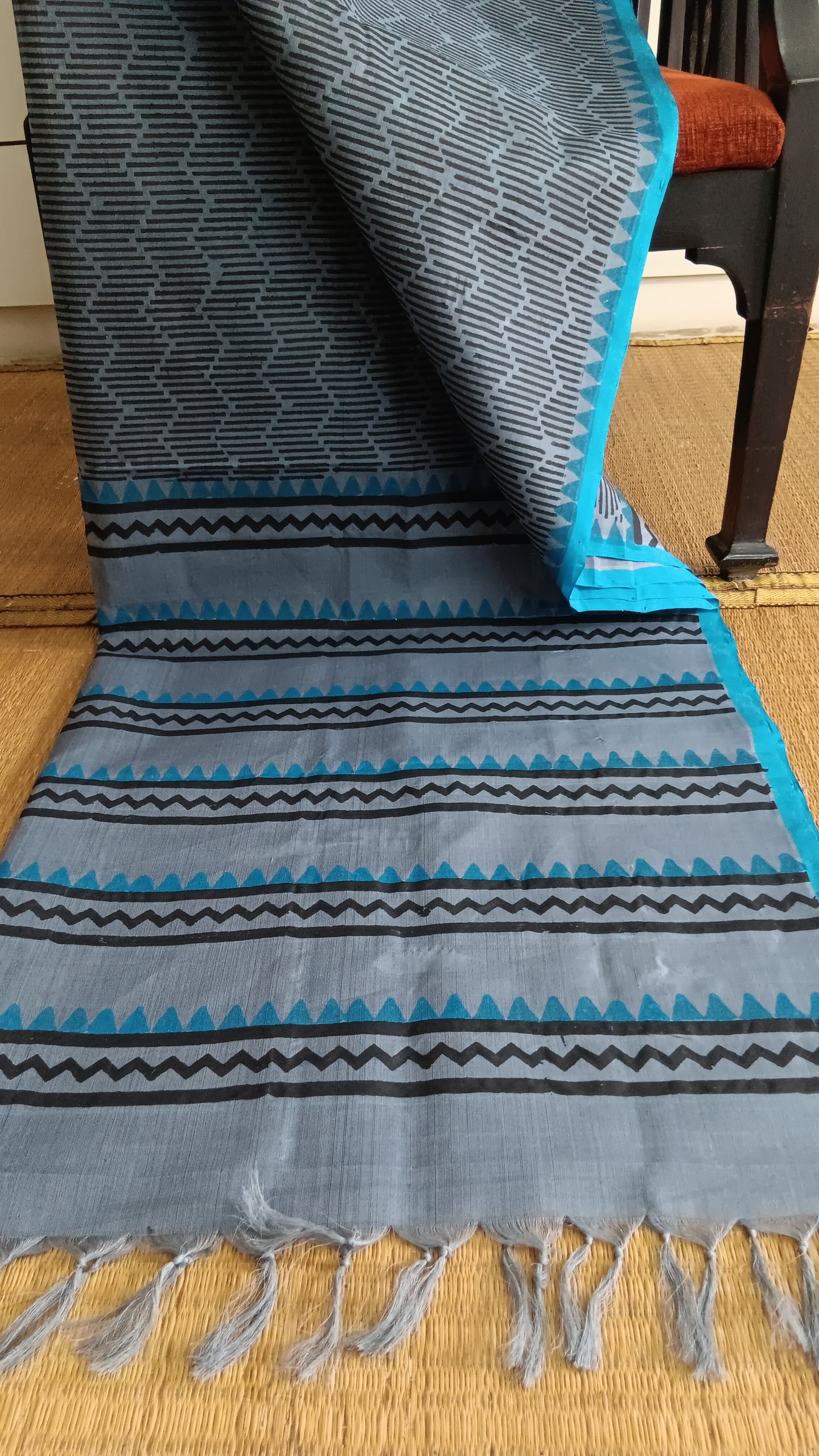 View from the top of the block printed pallu of a simple, hand woven, grey, daily wear, silk cotton saree
