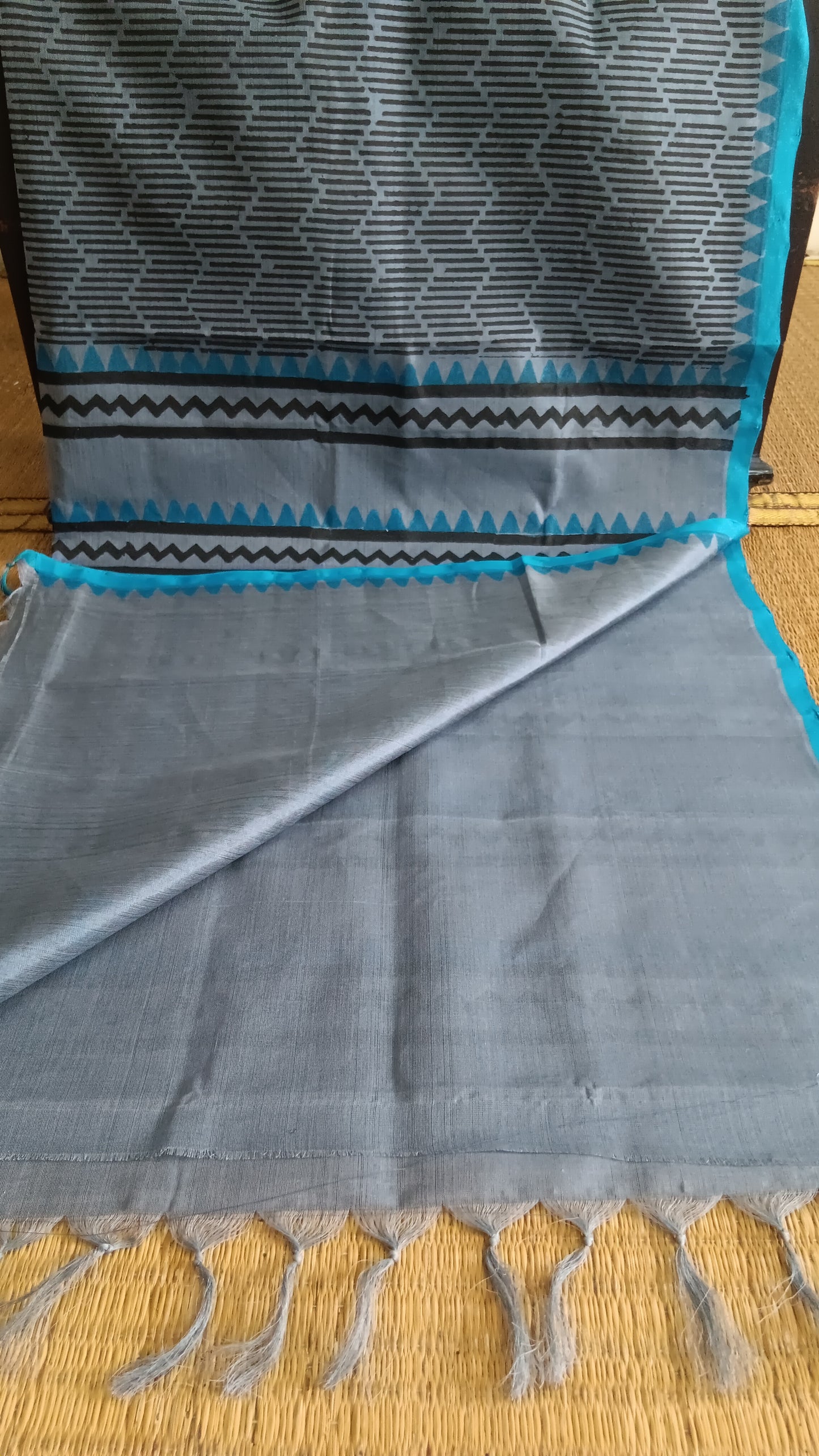 View from the top of the plain blouse of a simple, hand woven, grey, daily wear, silk cotton saree