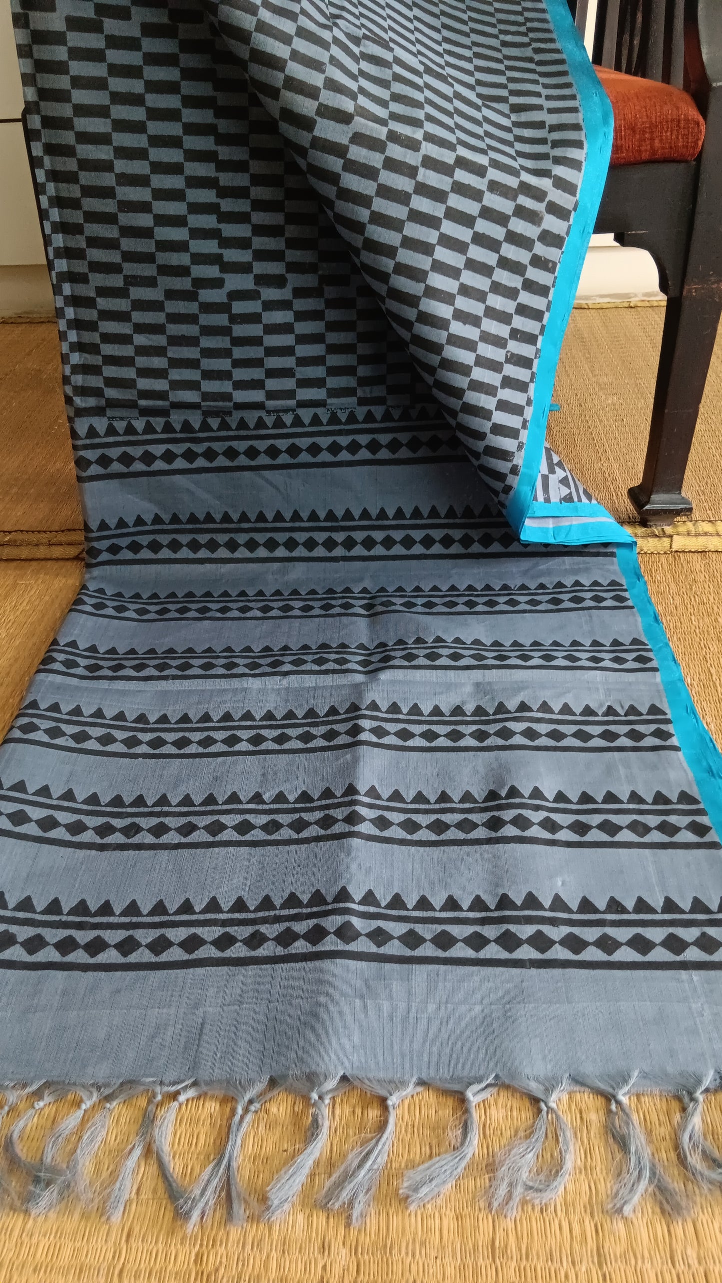 View from the top of the block printed pallu of a simple, hand woven, grey, daily wear, silk cotton saree