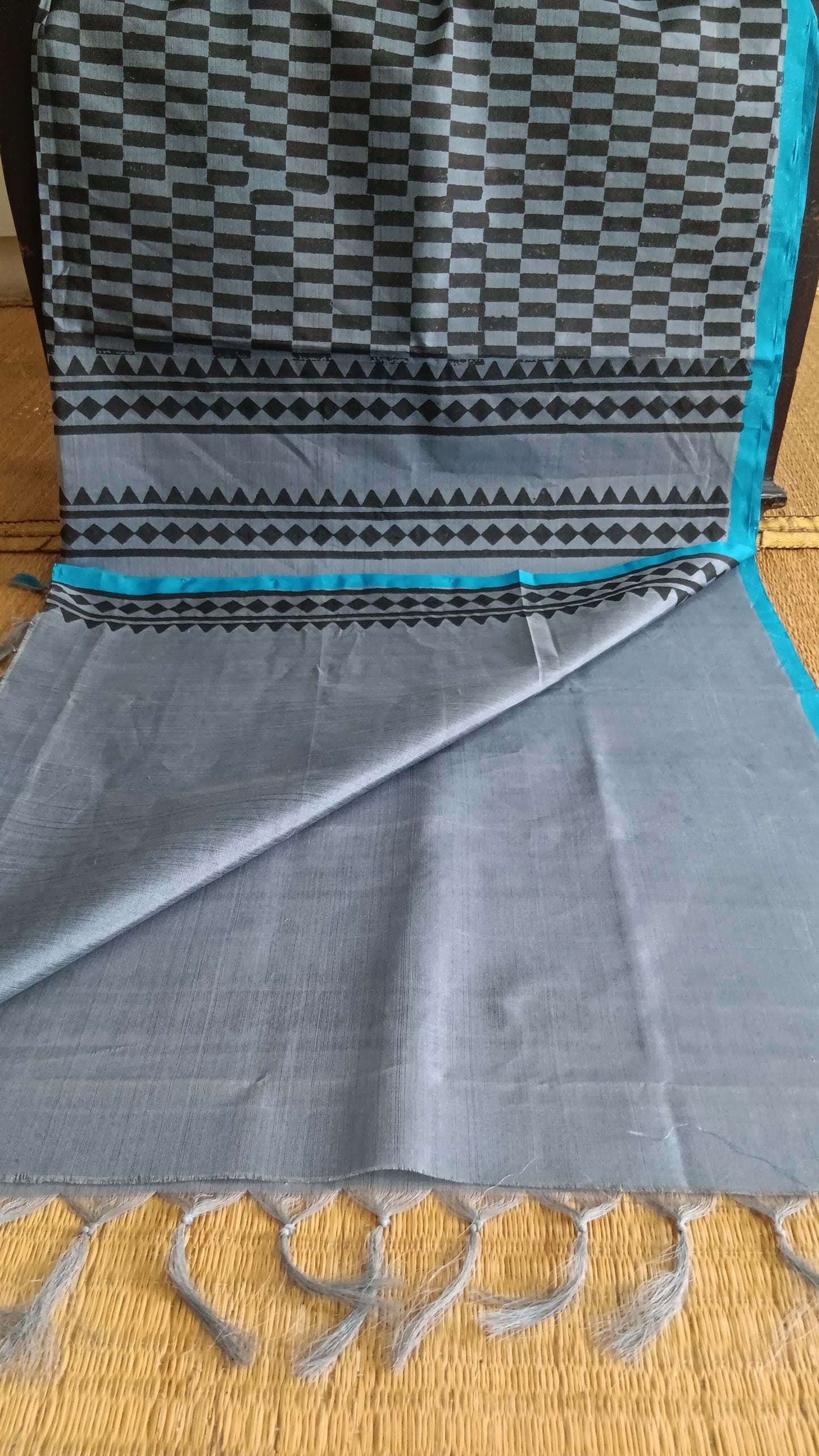 View from the top of the plain blouse of a simple, hand woven, grey, daily wear, silk cotton saree
