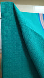 Close-up view of delicate geometric patterns block printed in a deeper turquoise shade on the turquoise cotton saree body.