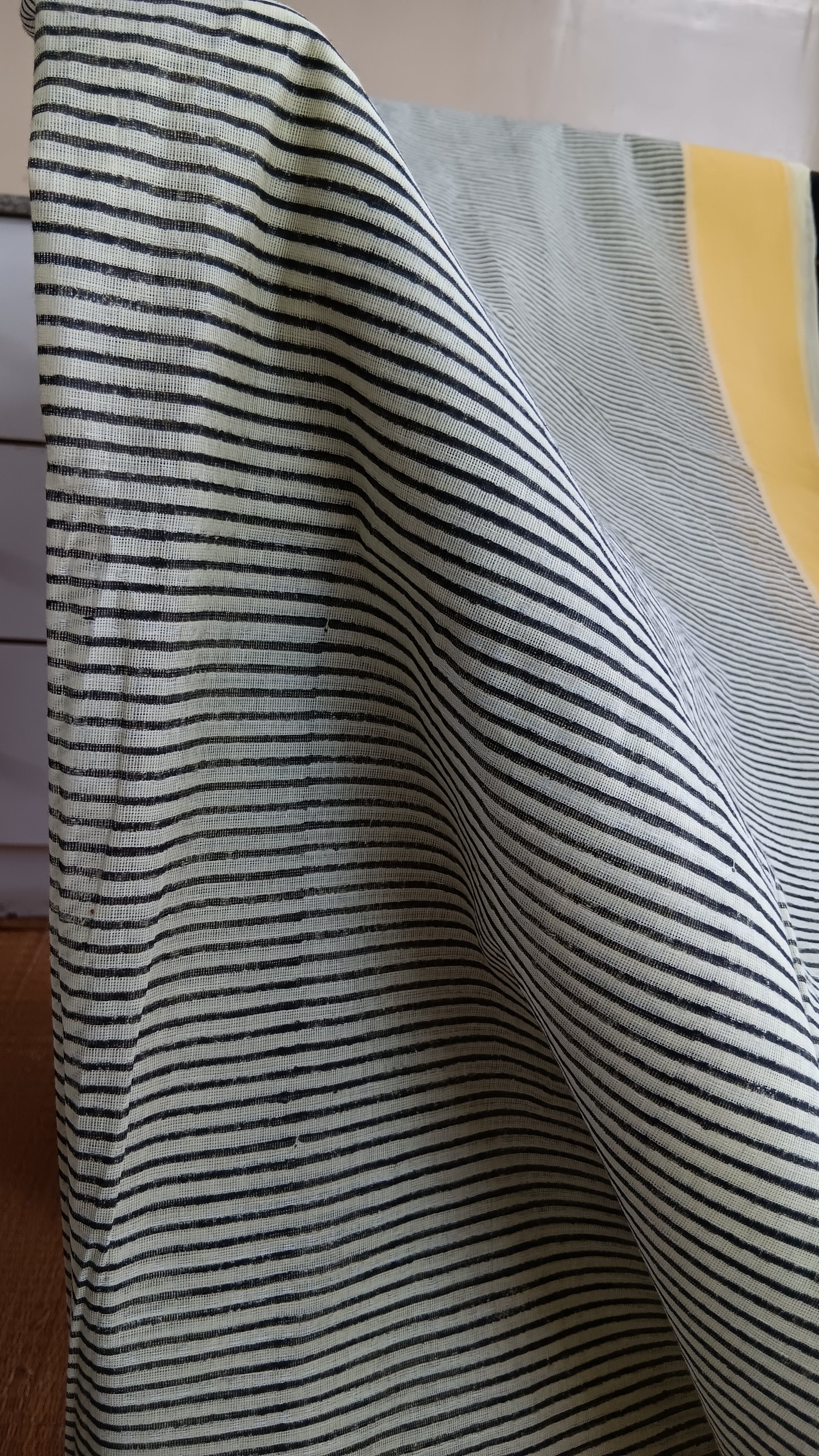 close up view of the stripes block printed on the body of a daily wear grey cotton saree with yellow border