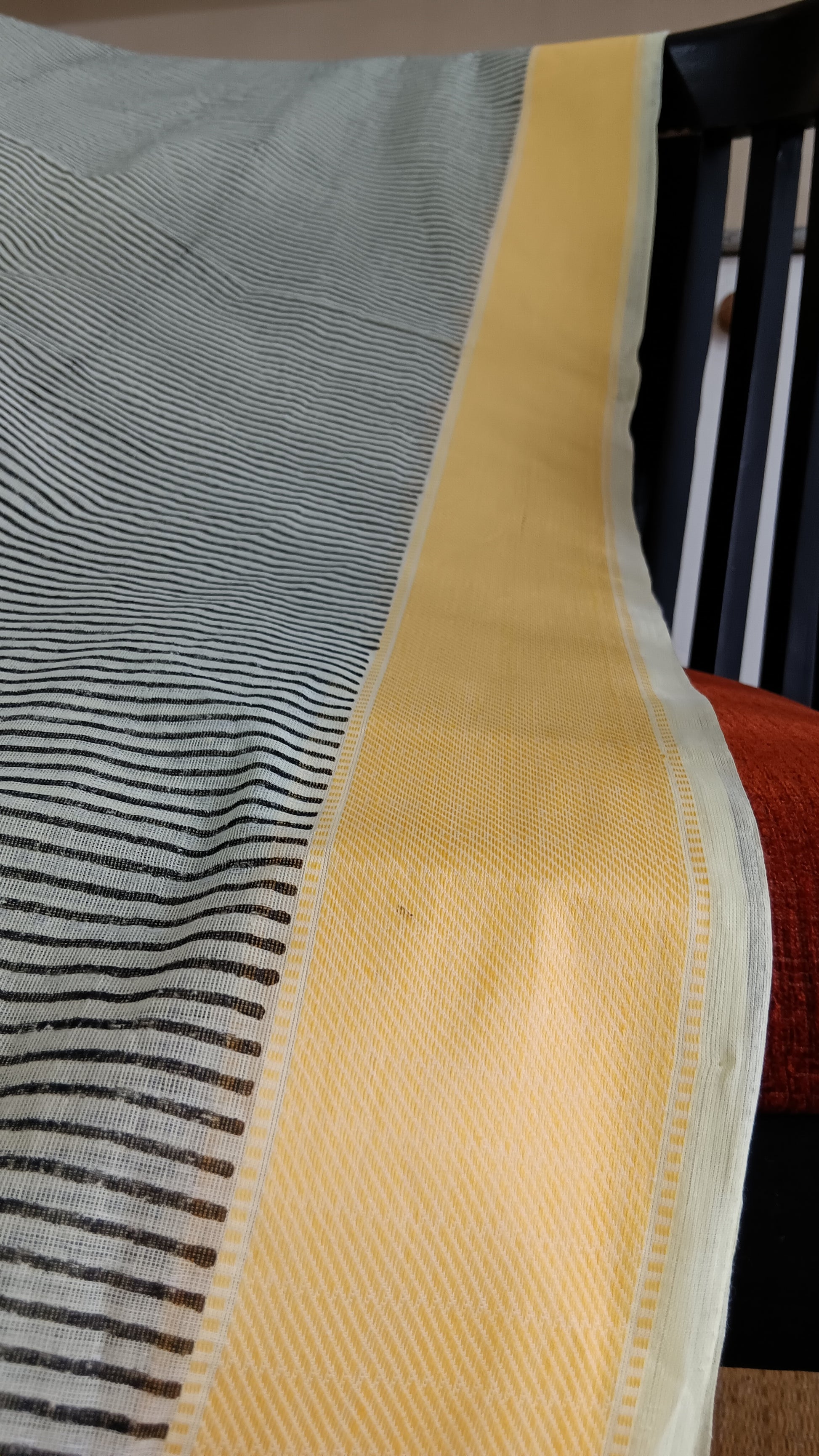 close up view of the yellow border of a daily wear cotton saree