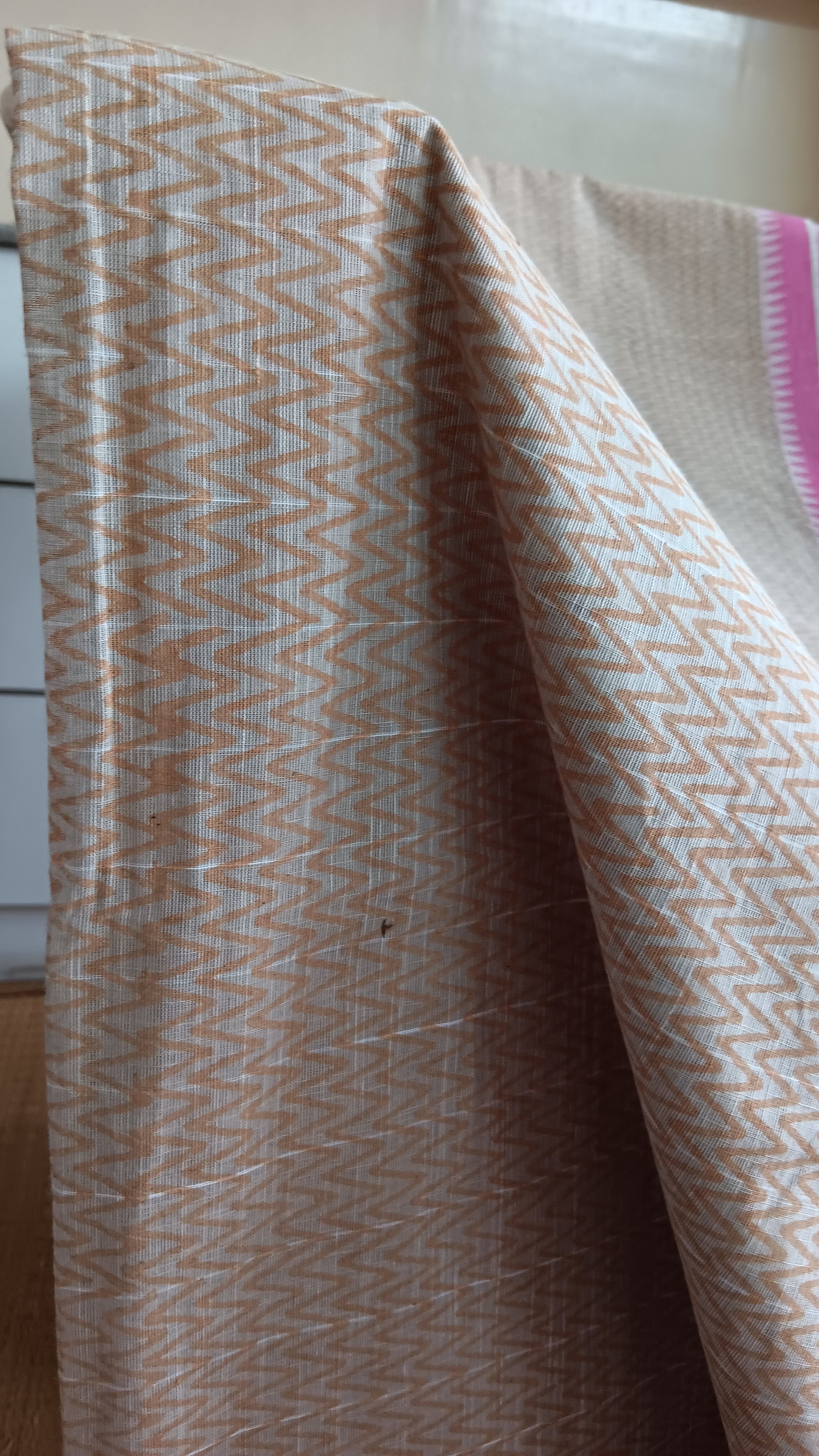 close up view of the chevron pattern block printed in beige on the body of a daily wear cotton saree