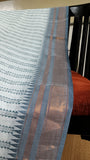 Close-up of the saree's bluish-grey border, showcasing a traditional twill weave with shimmering zari threads.