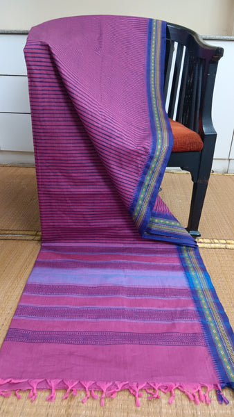 Classically elegant pink cotton saree featuring a bold blue striped print and a contrasting dark blue border. Perfect for work or everyday wear, it exudes confidence with a touch of modern flair.