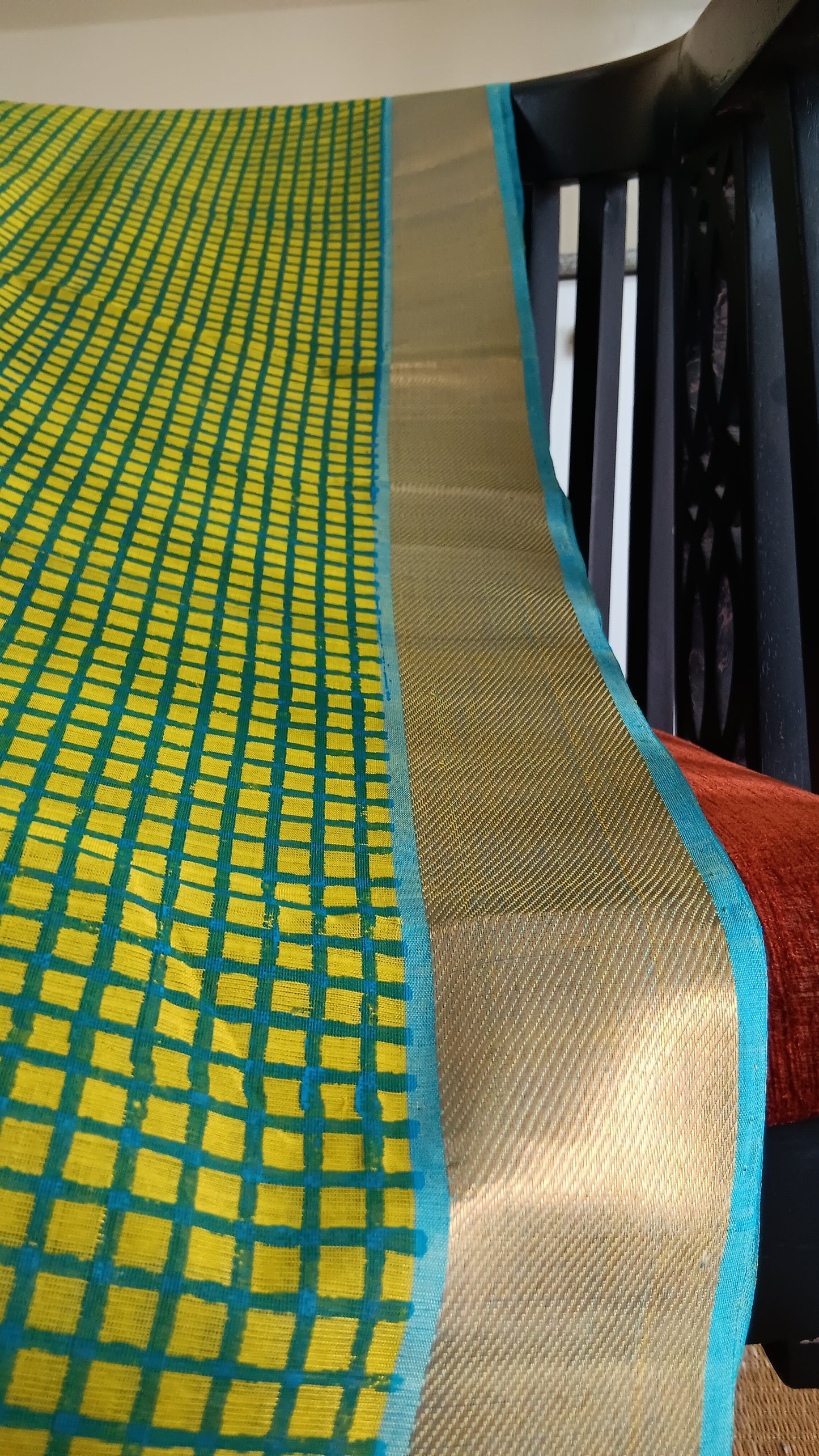 Close up view of the zari border of a simple hand woven, function wear, silk cotton saree