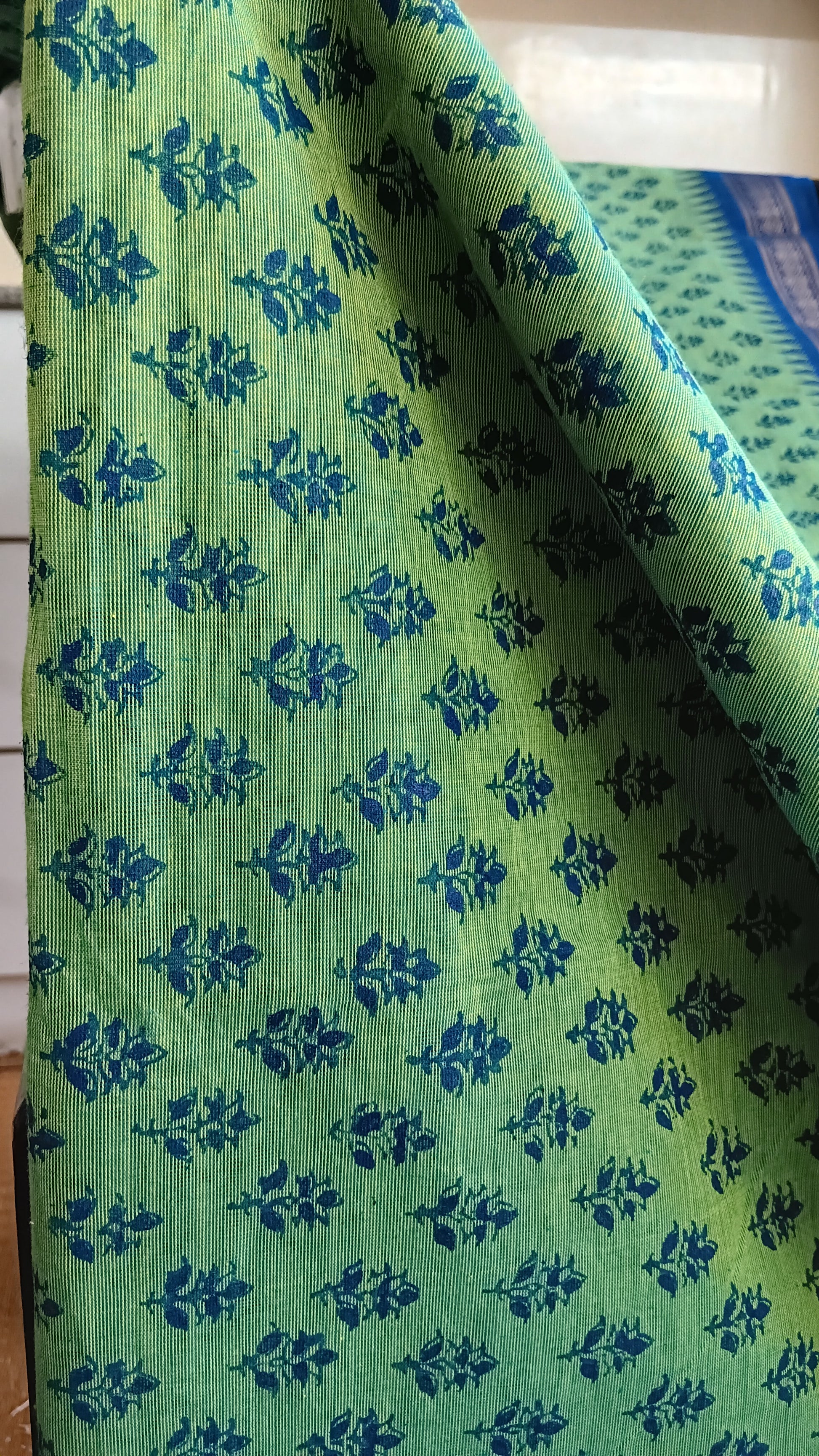 Close up view of the floral pattern block printed on the body of a funtion wear saree woven in south India