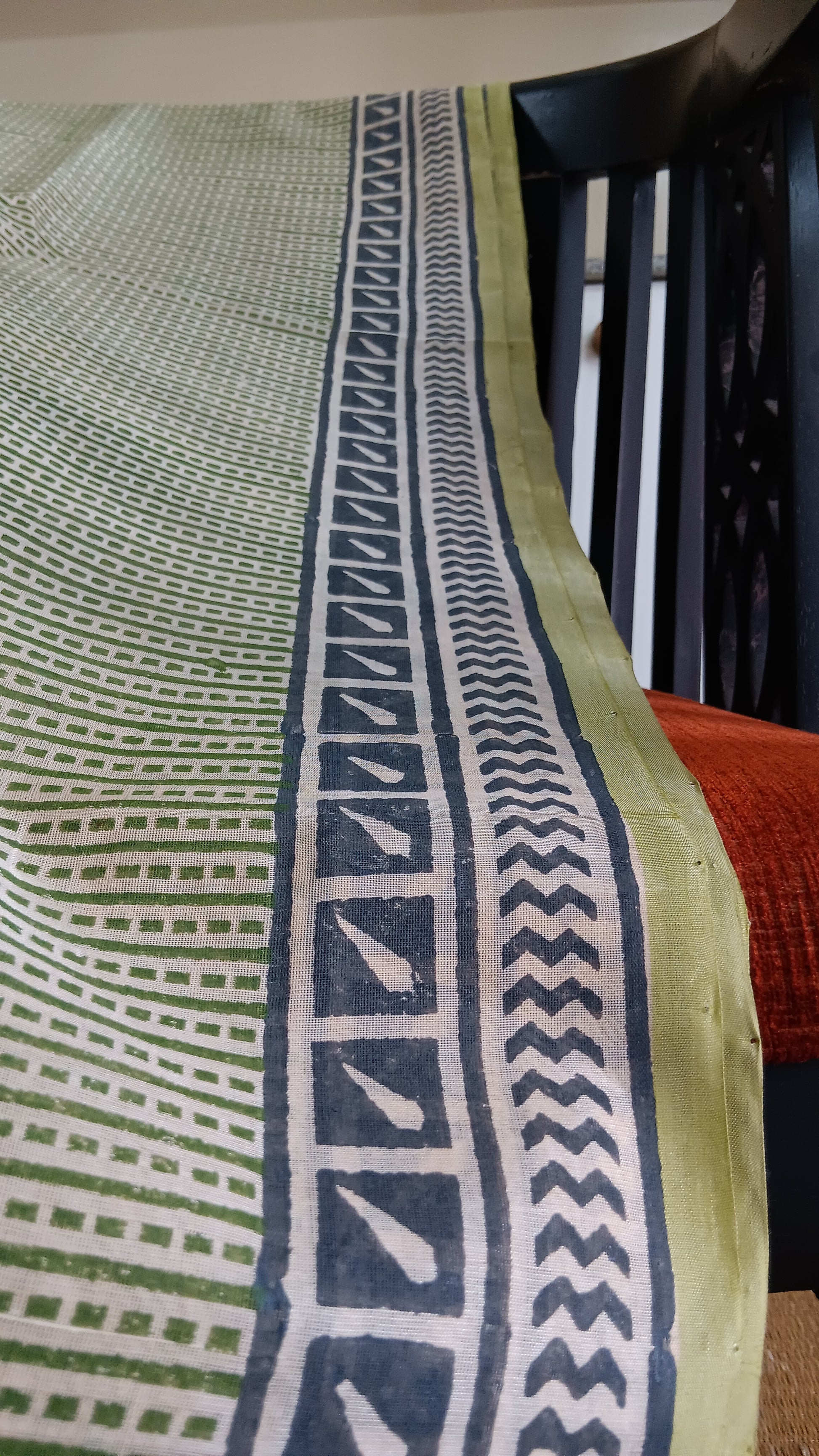 Close up view of the green border of a simple hand woven, green, daily wear, silk cotton saree