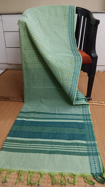 Light & Breezy: Light Green Cotton Saree with Blue Accents (Daily Wear). Featuring a refreshing light green base, calming blue block prints, and a contrasting dark green border, this saree is perfect for adding a touch of airy comfort to your daily routine.