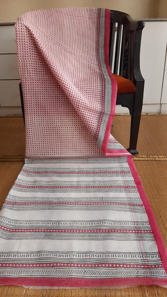 full view of a pink block printed daily wear kota cotton saree draped on a chair
