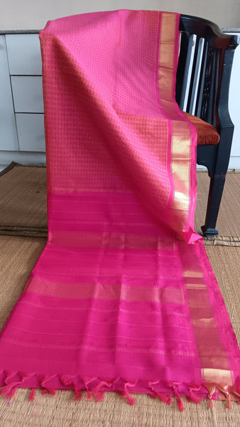 Handwoven silk cotton saree in vibrant pink with geometric block print and pink pallu.