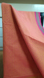 Close-up view of delicate geometric patterns block printed in a deeper pink shade on the blush pink cotton saree body.