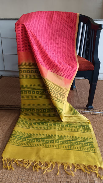Handwoven silk cotton saree in vibrant pink with geometric block print and mustard yellow pallu.