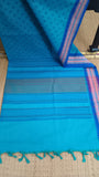 Top view of the saree's pallu in turquoise cotton, featuring the small temple motifs and a touch of the deep blue border.