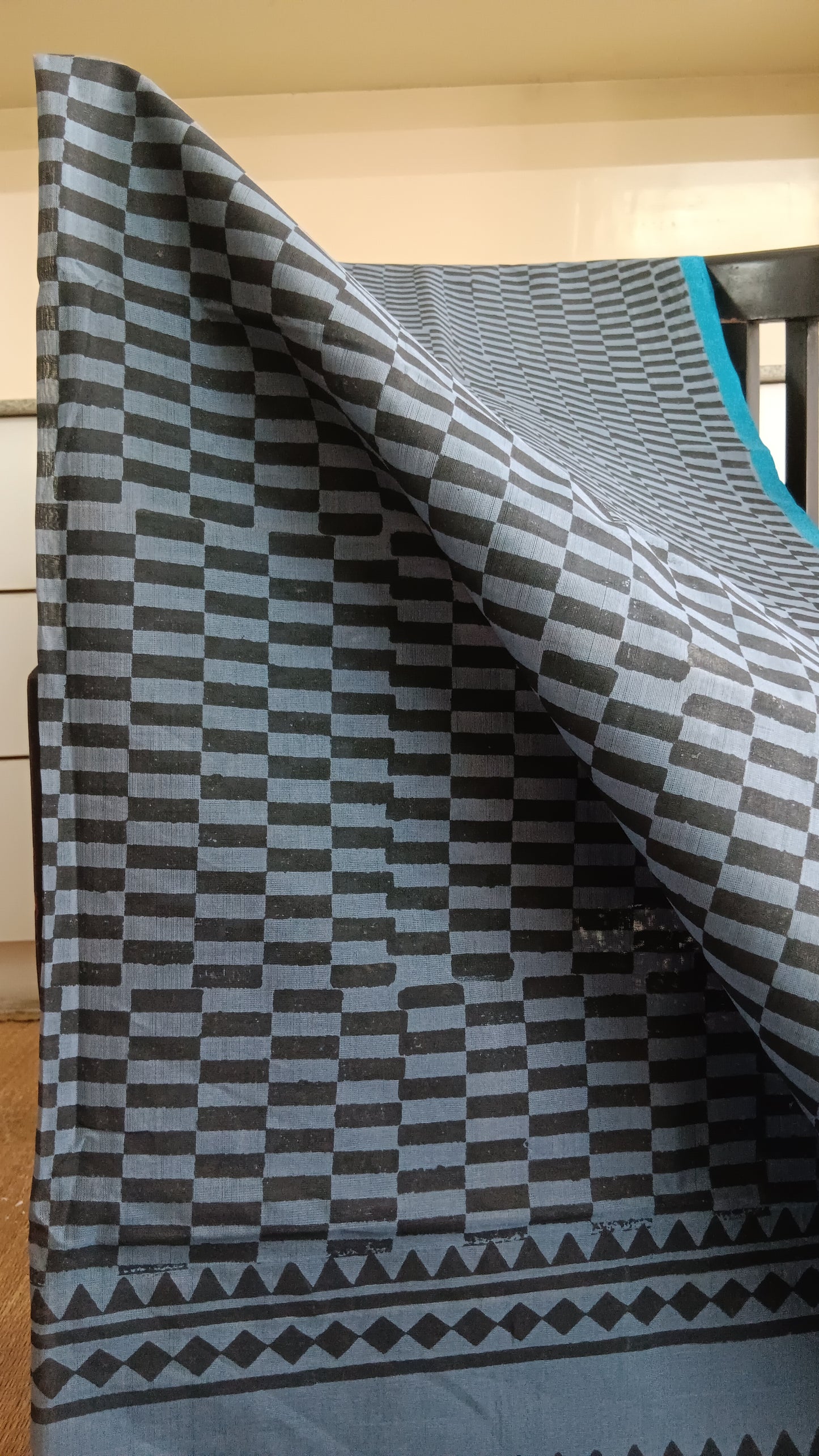 Close up view of the checks hand block printed on the body of a simple grey daily wear silk cotton saree
