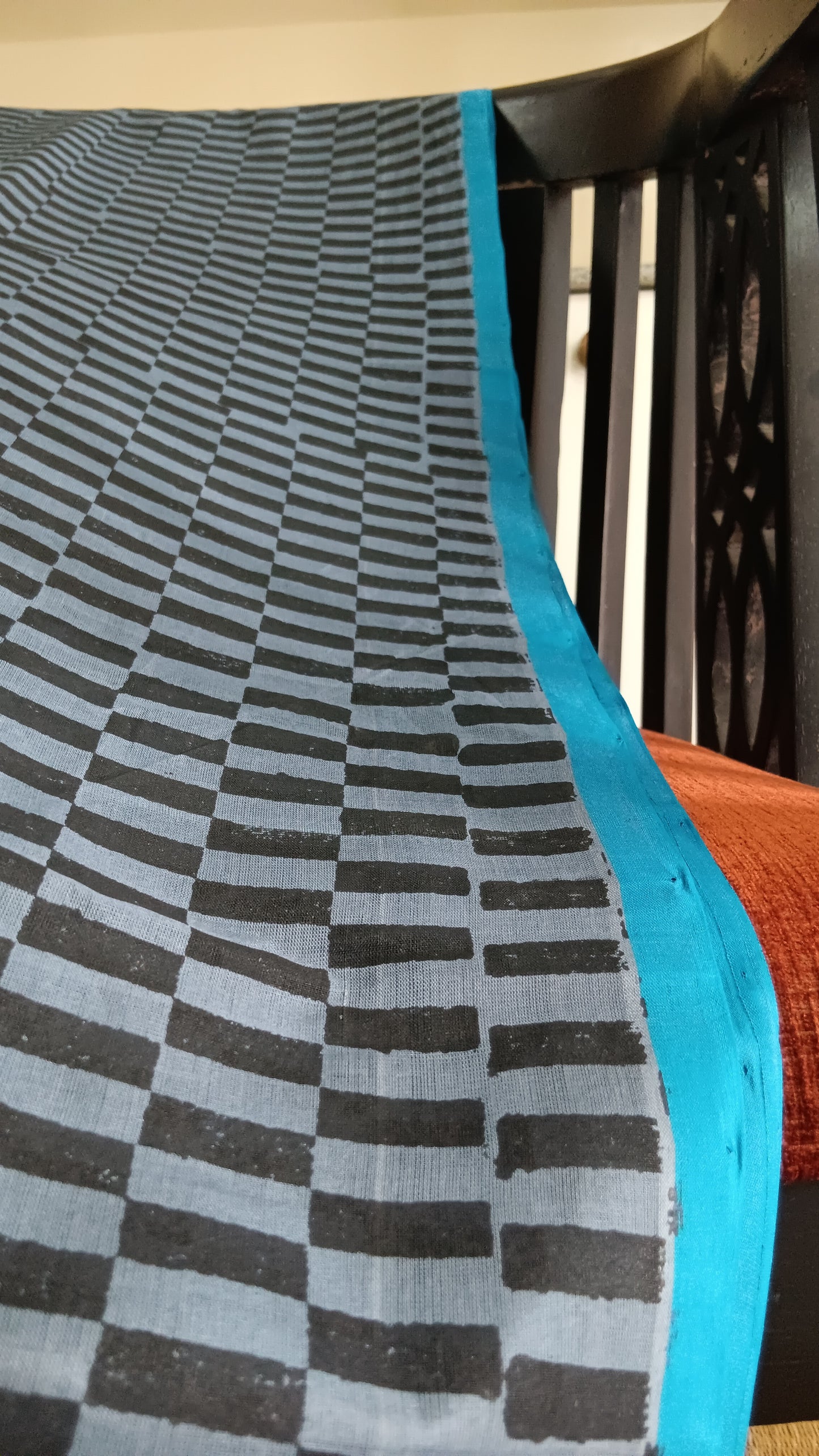 Close up view of the blue border of a simple hand woven, grey, daily wear, silk cotton saree