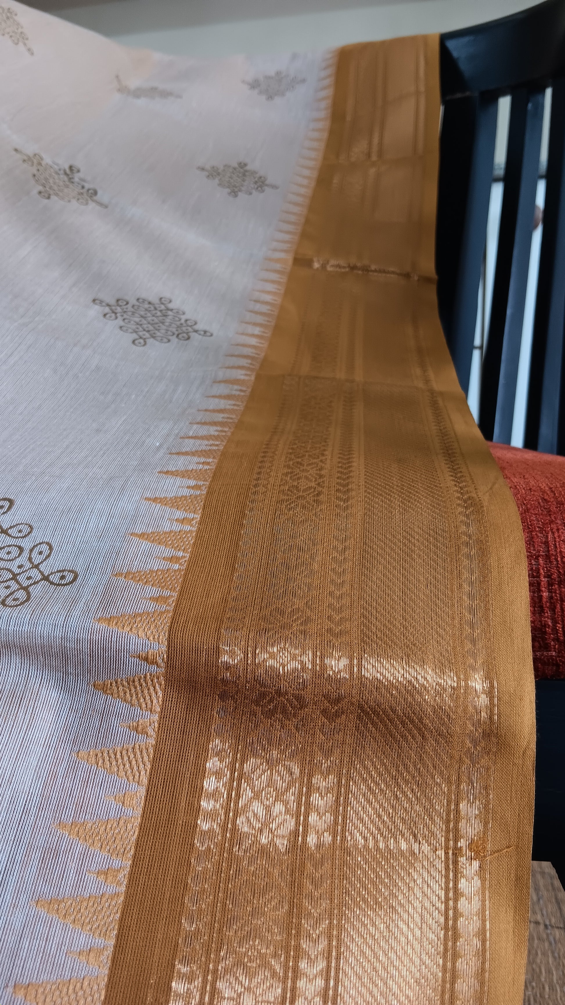 Close up view of the woven zari border of a function wear cotton saree from south India