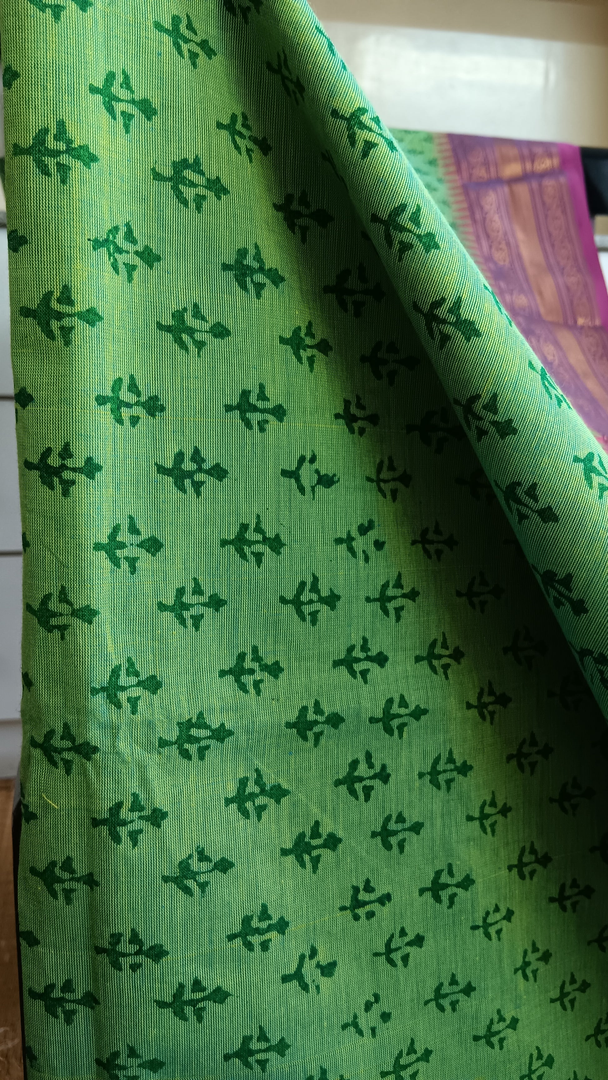 Close up view of the floral patterns block printed on the body of sea green south cotton function wear saree