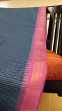 Close-up of the saree's pink border, featuring intricate traditional motifs woven in zari.