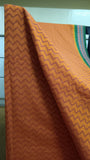 Close-up view of bold chevron patterns block printed in a deeper rust shade on the cotton saree body.