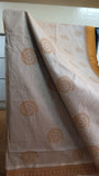 Close-up view of warli motifs block printed on the beige cotton saree body.