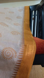 Close-up of the saree's mustard yellow temple border, showcasing traditional motifs intricately woven with zari.
