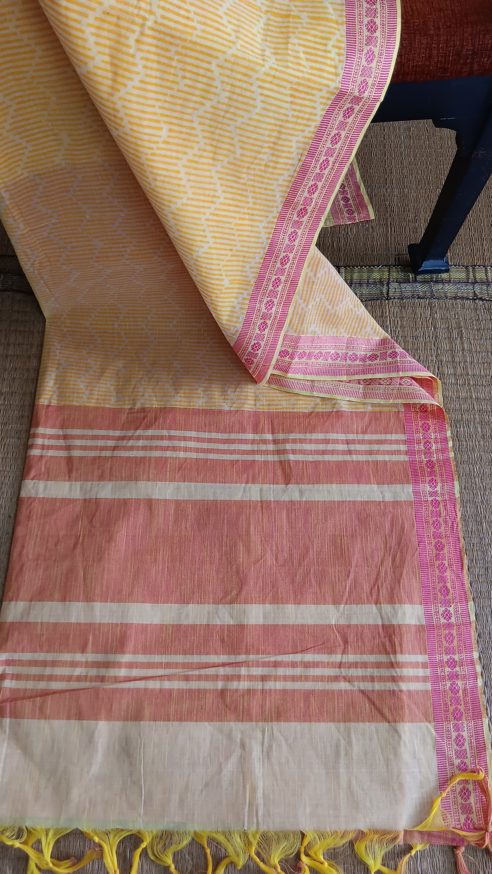 view from the top of the pallu of a yellow cotton saree with pink border