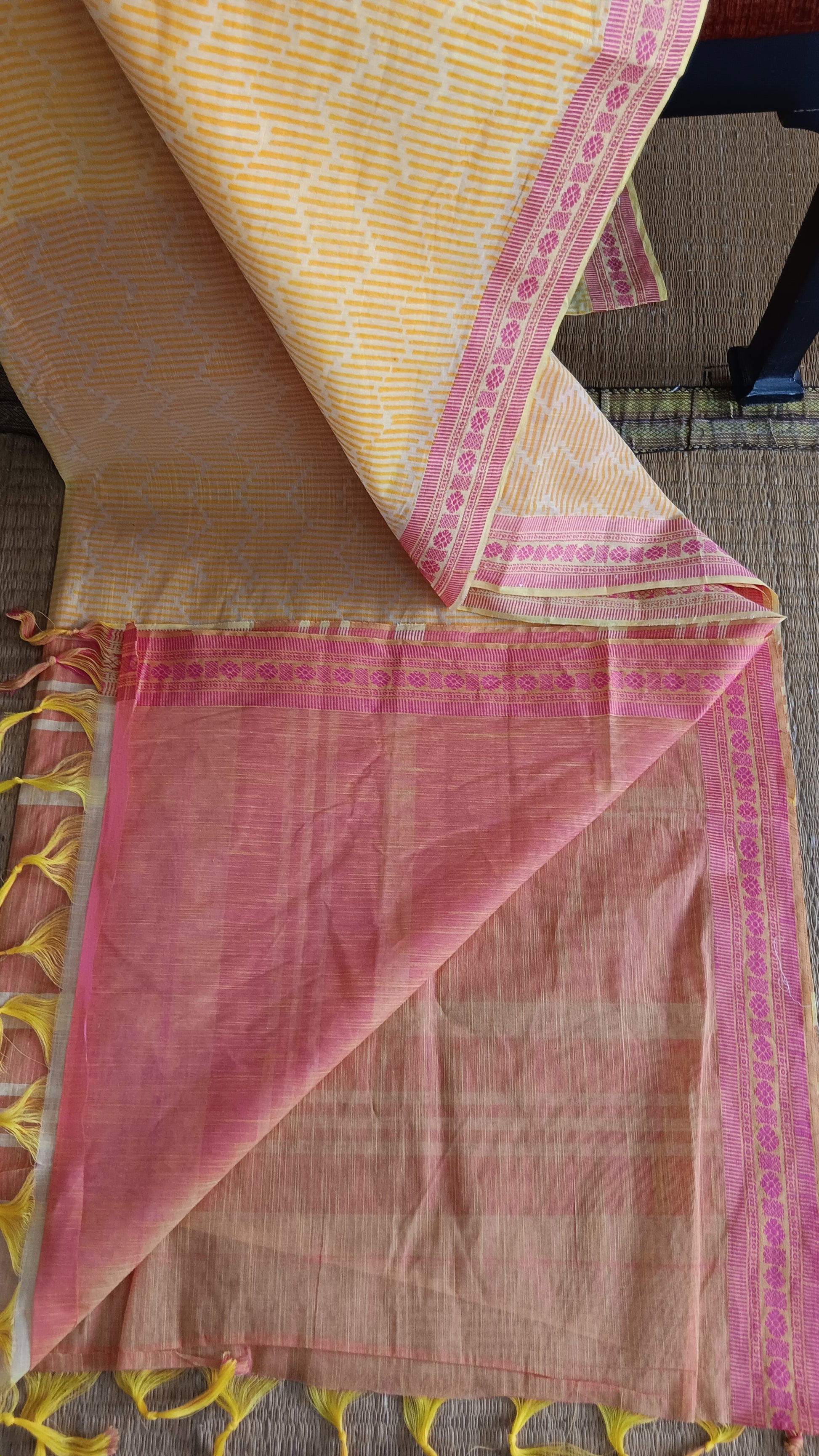 view from the top of the plain pink blouse of a yellow cotton saree